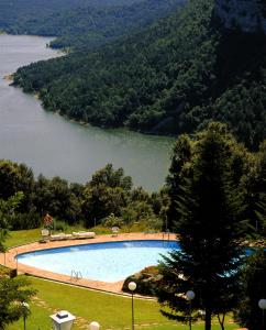 a large swimming pool with a view of a lake at Parador de Vic-Sau in Tavernoles