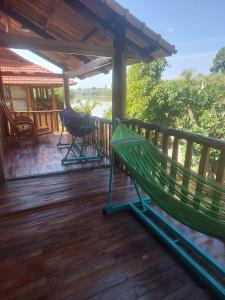 a hammock on the deck of a house at Green Bamboo Lodge Resort in Cat Tien