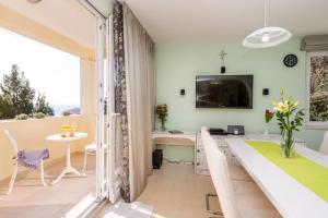 sala de estar con mesa y TV en la pared en Sea View Apartments, en Dubrovnik