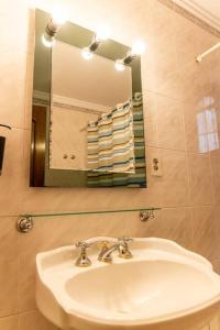y baño con lavabo, espejo y toallas. en Amplio apartamento en pleno centro de Salta en Salta