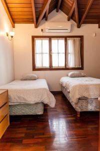 Habitación con 2 camas, suelo de madera y ventanas. en Amplio apartamento en pleno centro de Salta en Salta