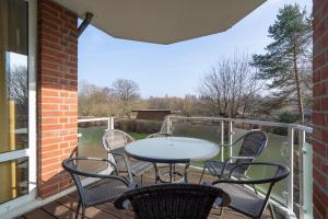 a patio with a table and chairs on a balcony at Ferienhof am Mühlenteich App 29 in Timmendorfer Strand