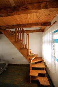 scala in legno in una stanza con finestra di CORBU ACCOMMODATION a Corbu