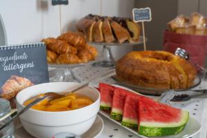 uma mesa com vários tipos de pastelarias e frutas em Hotel Mom Assisi em Assis