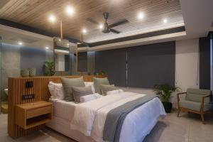 a bedroom with a large bed and a chair at Ballito Sands Penthouses in Ballito