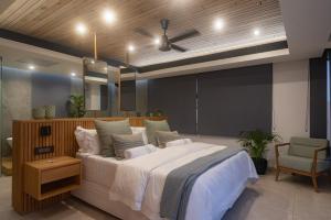 a bedroom with a large bed and a chair at Ballito Sands Penthouses in Ballito +52 photos