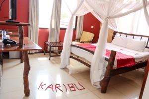 a bedroom with a bed with a sign that reads karna at Bridge Hotel Mombasa in Mombasa