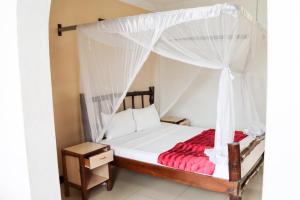 um quarto com uma cama de dossel em Bridge Hotel Mombasa em Mombasa