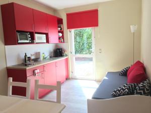 a living room with red cabinets and a kitchen at die Senfbude - schöne, ebenerdige 2-Raum-Apartments mit Stellplatz und Terrasse in Leipzig +24 photos