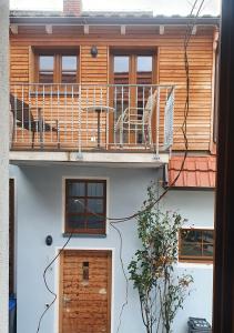 a building with a balcony with a table and a chair at Ferienwohnung im Bückle in Gottenheim