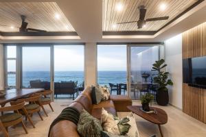 sala de estar con sofá y vistas al océano en Ballito Sands Penthouses, en Ballito