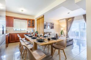 a kitchen and living room with a table and chairs at Villa Thamyris in Kalórrouma