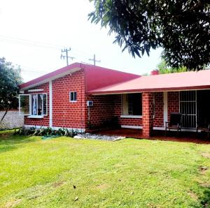 una casa de ladrillo rojo con techo rojo en Casa para vacacionar en la playa, en Casitas