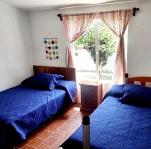 1 dormitorio con 2 camas y ventana en Casa para vacacionar en la playa, en Casitas