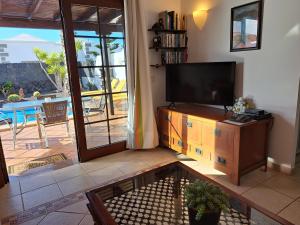sala de estar con TV de pantalla plana y patio en Villa de la Paz, en Playa Blanca