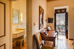 La salle de bains est pourvue d'un bureau, d'un lavabo et d'une table. dans l'établissement Ξενώνας Αρχοντικό Ελληνοπύργου, à Ellinopyrgos