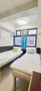 2 camas en una habitación con ventana en Apple Hostel, en Hong Kong