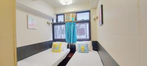 mały pokój z 2 łóżkami i oknem w obiekcie Apple Hostel w Hongkongu