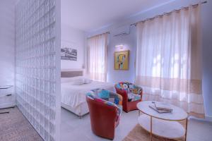 um quarto com uma cama, 2 cadeiras e uma mesa em Right House Sur le Port - Harbour View em Cagliari