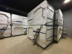 a row of white machines in a room at My Capsule Hotel in Johor Bahru