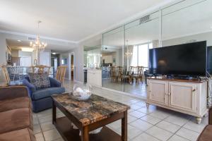 a living room with a large flat screen tv at Incredible Great Deals On This Hidden Gem Gulf Front Condo at The Pearl Sleeps 8 in Navarre