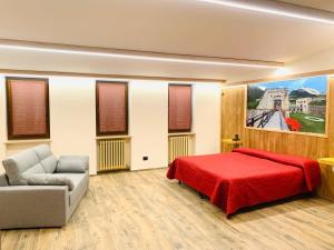ヴィナーディオにあるHotel Ristorante Ligureのベッドルーム(赤いベッド1台、ソファ付)