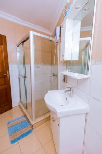 een badkamer met een douche en een wastafel bij KAMI LUXURY APARTMENTS in Kigali