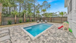 un patio trasero con piscina y parque infantil en Alluring Private Pool Sweet Haven at Dune Allen, en Santa Rosa Beach