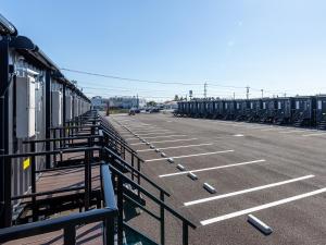 a parking lot with rows of parked cars at HOTEL R9 The Yard Kawaminami in Kawaminami