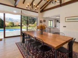 - une salle à manger avec une table et des chaises en bois dans l'établissement Impresionante villa entre mar y montaña, à La Cavada