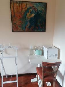 奧里奧阿塞里奧的住宿－Airport Stop，墙上的一张带椅子的白色桌子上的绘画