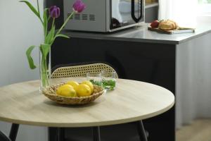 a table with a bowl of lemons and a vase at Cozy 1BR Studio Apartment in Heart of Tel Aviv by Sea N' Rent in Tel Aviv