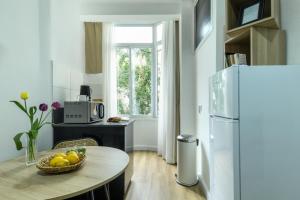 uma cozinha com uma mesa e um frigorífico em Cozy 1BR Studio Apartment in Heart of Tel Aviv by Sea N' Rent em Tel Aviv