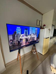 een grote flatscreen-tv op een stand in een woonkamer bij SOYA`S HOUSE in Busan