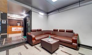 a waiting room with a leather couch and a table at Treebo Vetri Supreme Residency in Chennai