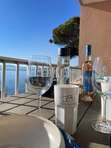 a table with two glasses and a bottle of wine at Appartement Vue Mer Golfe de Saint-Tropez in Sainte-Maxime