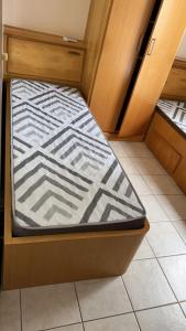 a small bed in a small room with a mattressvisor at AP com Piscina em Porto Belo in Porto Belo