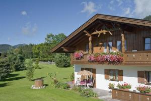 een huis met een balkon met bloemen erop bij Ferienwohnung Alpenwelt in Wallgau