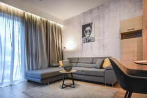 salon z kanapą i stołem w obiekcie Apartamenty Na Wyspie - Baltic Park - Apartamenty z sypialnią i parkingiem - ul Uzdrowiskowa 24-34 w Świnoujściu