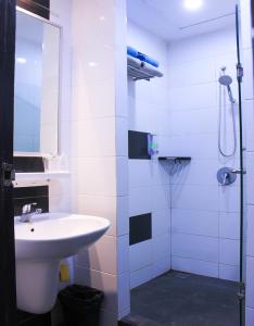 bagno bianco con lavandino e doccia di Suzuya Hotel Bagan Batu a Bagansinembah