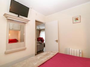 a bedroom with a bed and a flat screen tv on the wall at Peacehaven in Liskeard