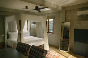 um quarto com uma cama, uma mesa e cadeiras em Domu Mia Villa Siargao em General Luna