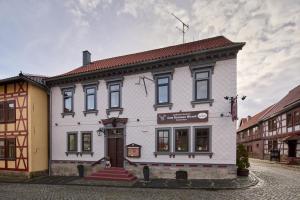 Landhotel Brauner Hirsch في Kammerforst: مبنى ابيض بسقف احمر على شارع