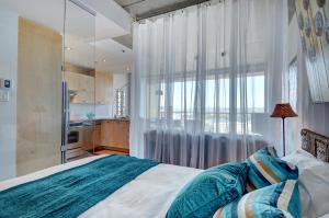 1 dormitorio con cama y ventana grande en Les Immeubles Charlevoix - Le 760314, en Quebec