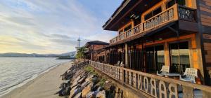 a building on the beach next to a body of water at De Baron Resort in Kuah
