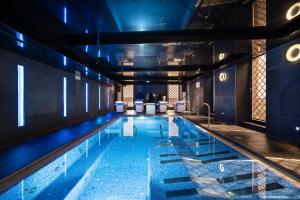 a large swimming pool with blue lighting in a building at Eurostars Vía de la Plata in Astorga