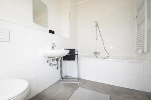a white bathroom with a sink and a toilet at Air Apartments 3 in Bremen