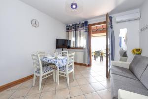 a living room with a table and chairs and a couch at Appartamento Al Cascinale in Desenzano del Garda