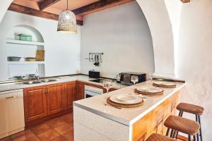 a kitchen with a counter with two chairs and a sink at Cortijo El Guarda in Almería
