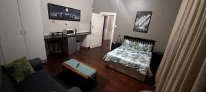 uma pequena sala de estar com uma cama e uma mesa em Glen Lilly Self Catering em Parow